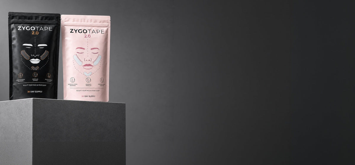 Zygo Tape black and pink pouches standing on a plinth against a dark backdrop