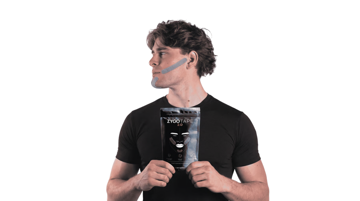 Man wearing Zygo Tape mouth tape on his jawline, holding a black Zygo Tape 2.0 pack
